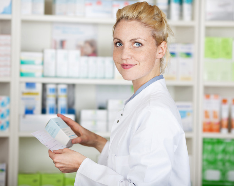Mulher com jaleto branco segurando um medicamento e uma receita
